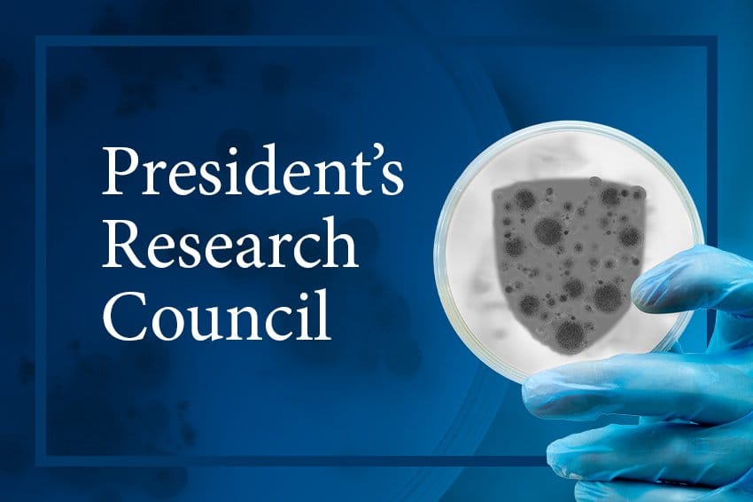 Blue background with a photo of a gloved hand holding a petri dish. Inside the petri dish is a bacterial colony in the shape of a shield.