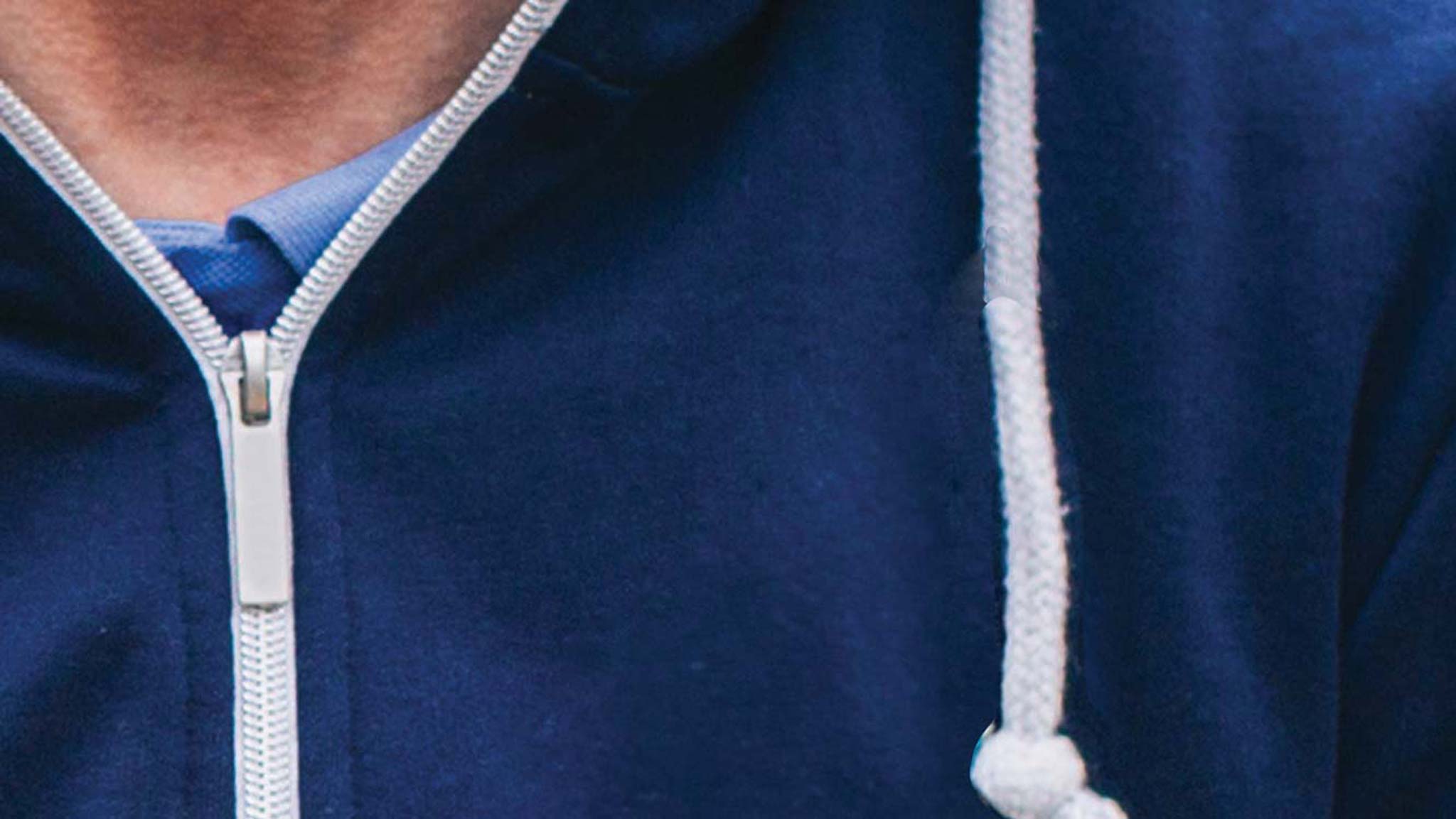 A closeup image of a zipper on a man's hooded sweatshirt.