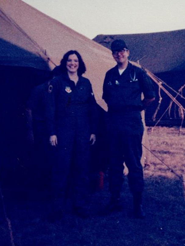 Gladys Young in uniform next to a uniformed man outside a desert tent.