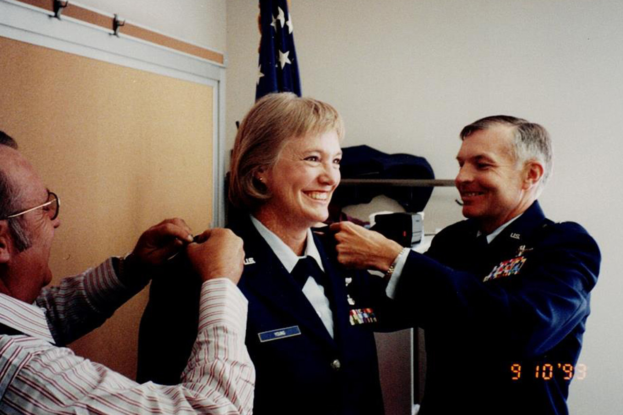 Two men pinning eagle medals to Gladys Young's uniform.