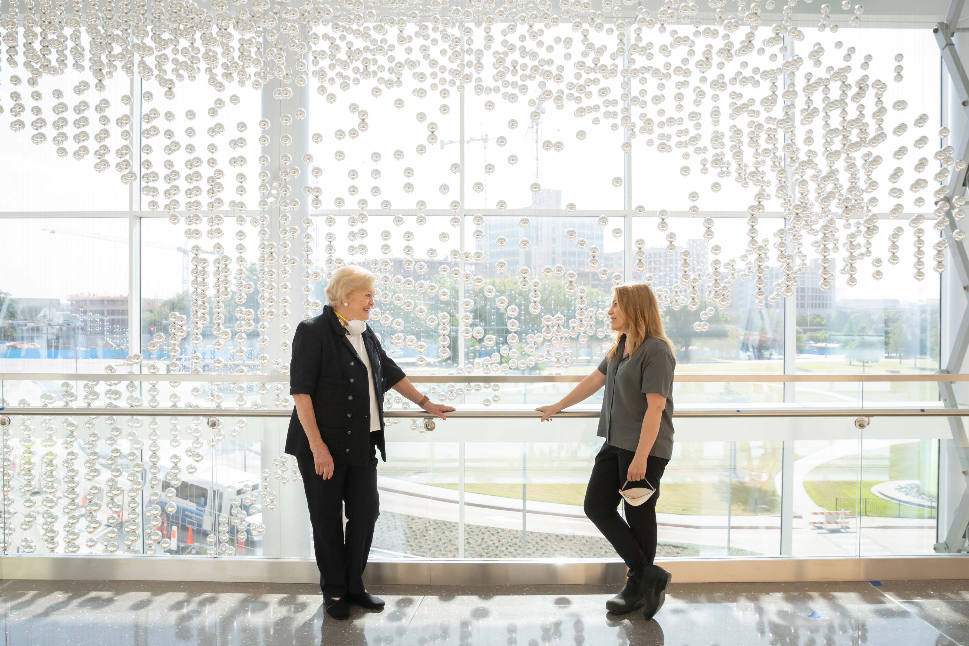 Artist Danielle Roney visits with donor Barbara Lemmon and UT Southwestern President Dr. Daniel K. Podolsky during the installation of Myriad