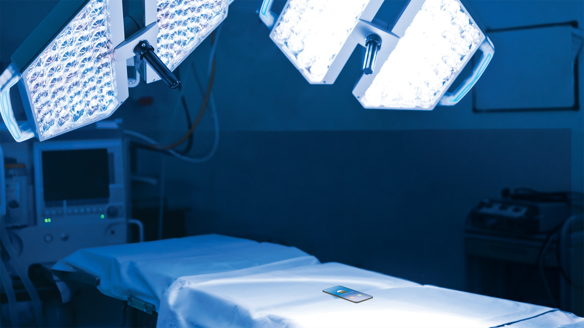 An operating table with a phone laying on the guerney.