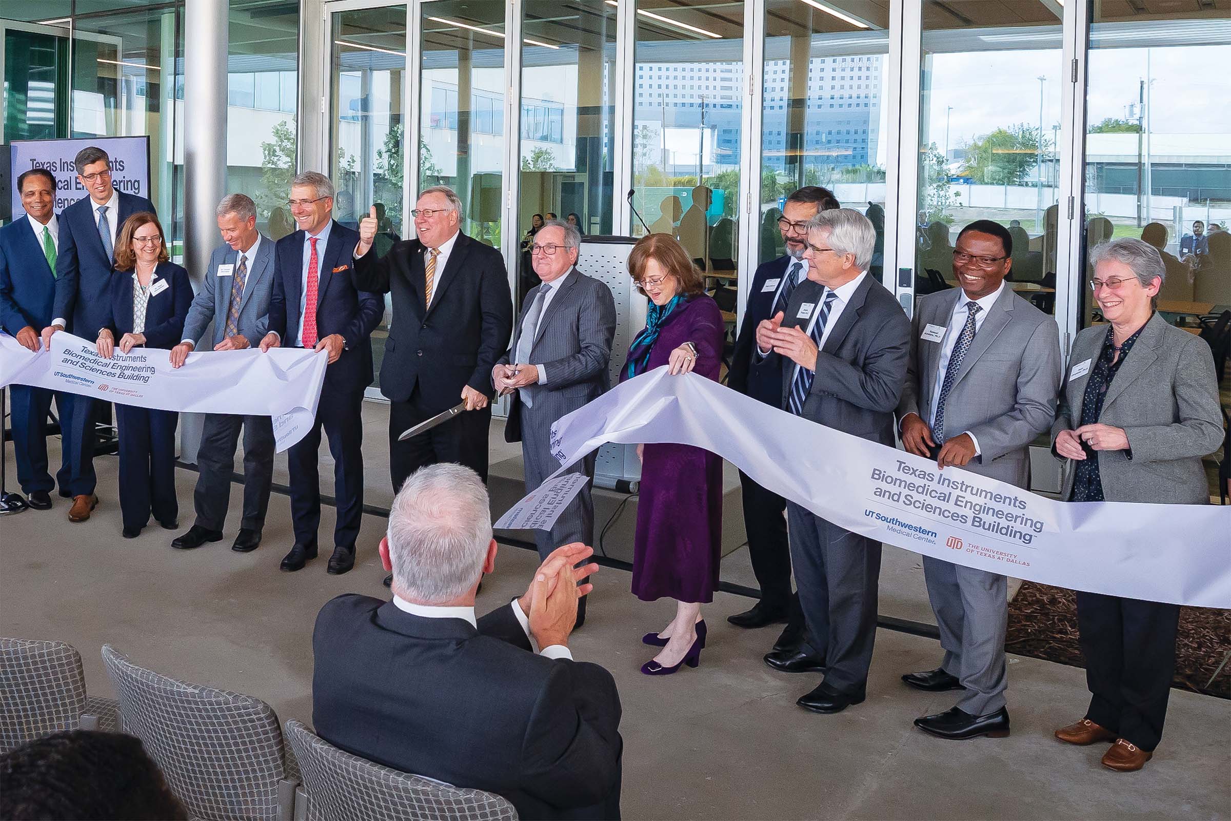 Leaders from the UT System, UT Southwestern, UT Dallas, and Texas Instruments cutting of the ceremonial ribbon in front of the Texas Instruments Biomedical Engineering and Sciences Building.