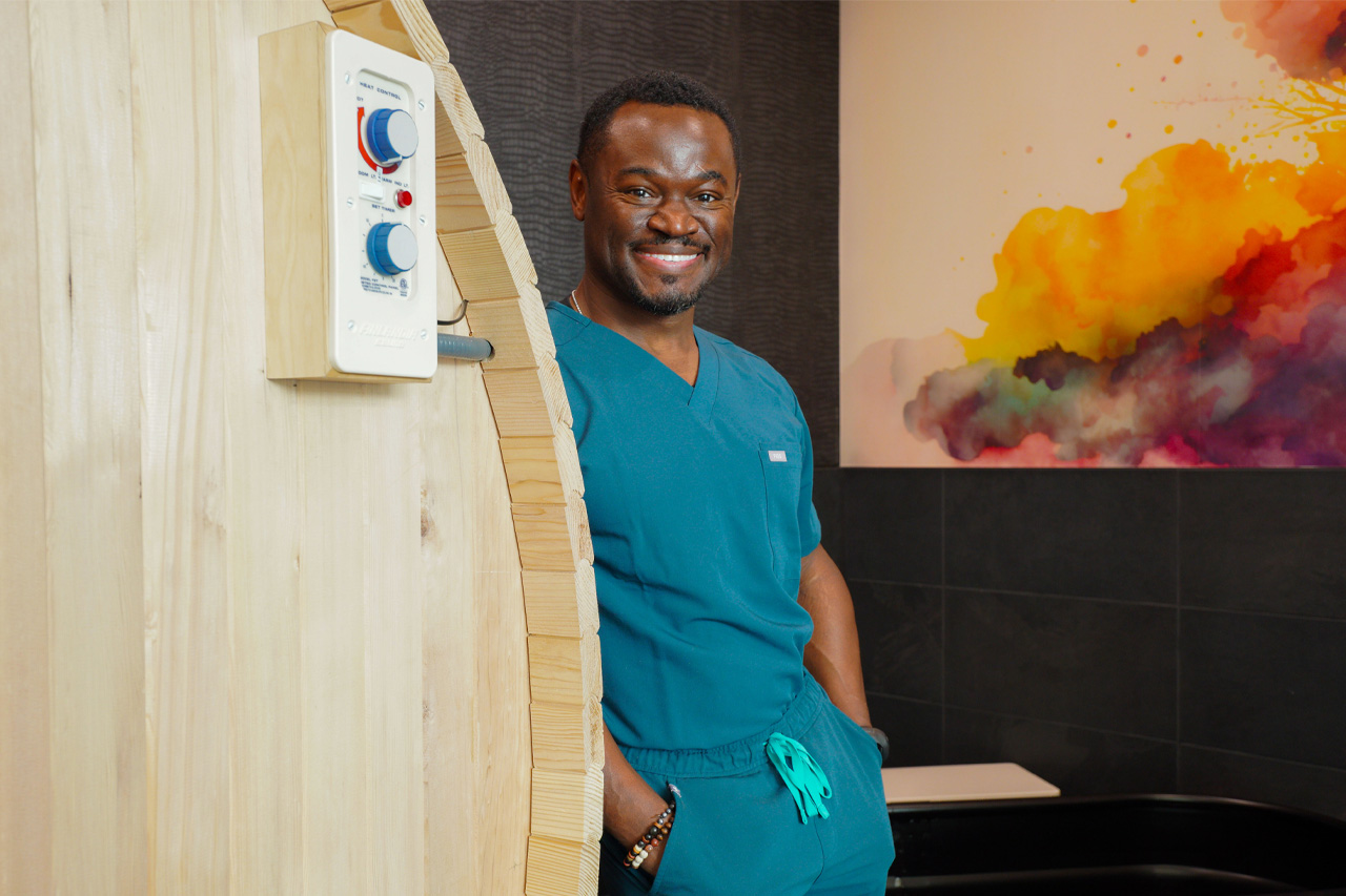 Dr. Kenneth Johnson leaning against a physical tharapy machine inside of his center.