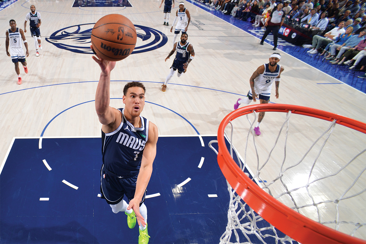 Dwight Powell jumping with the basketball toward the basket during an NBA game.