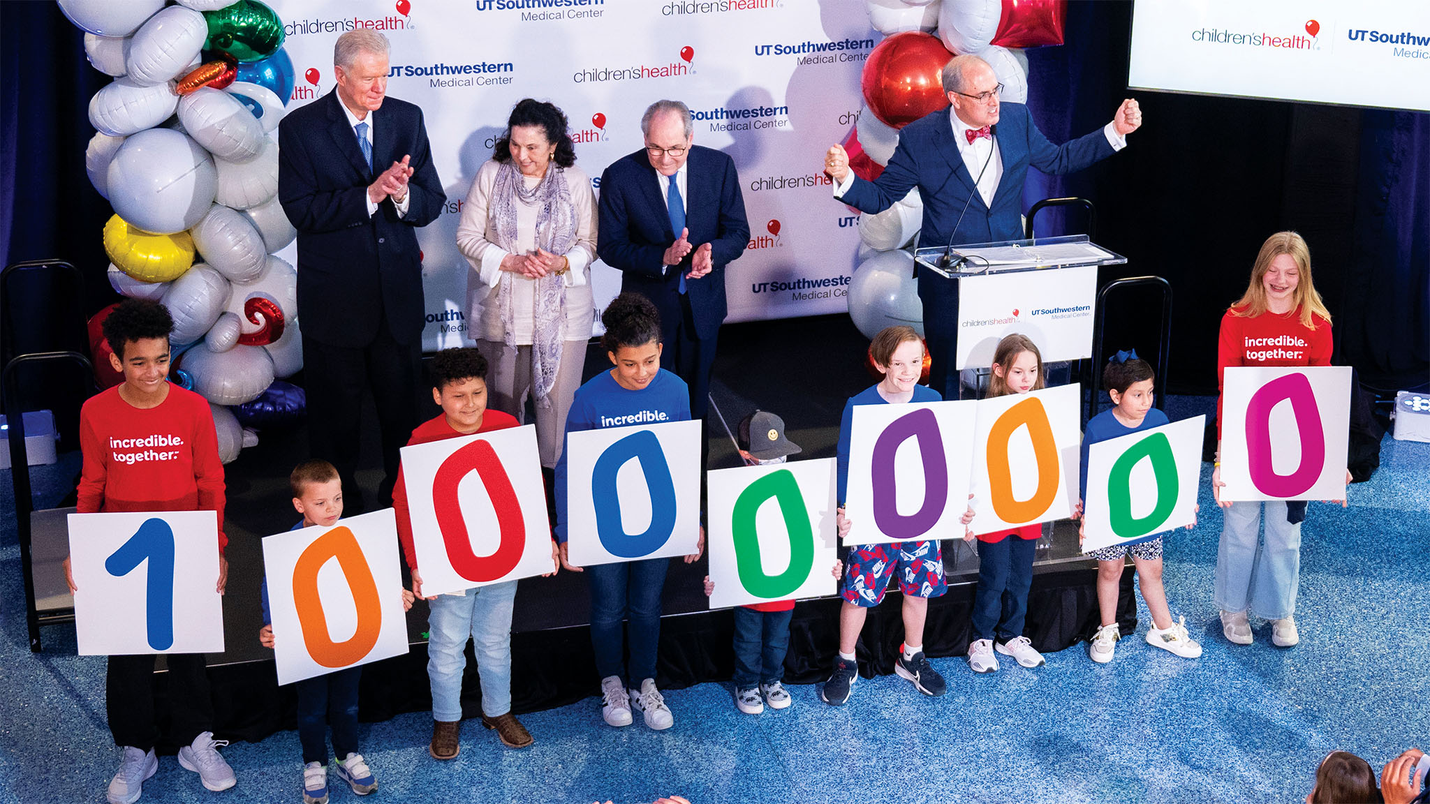 Surrounded by children and community members, Children’s Medical Center Foundation President Brent Christopher, at the podium, announces the Pogue family’s gift at Children’s Medical Center Dallas.